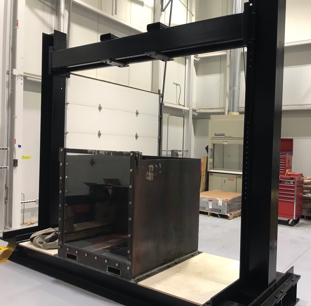 Photograph of the soil box and the reaction frame in the structural dynamics laboratory.